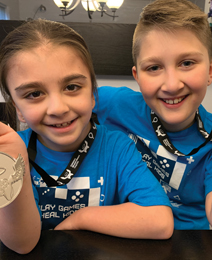 Blayke and brother Ethan holding their Extra Life medals